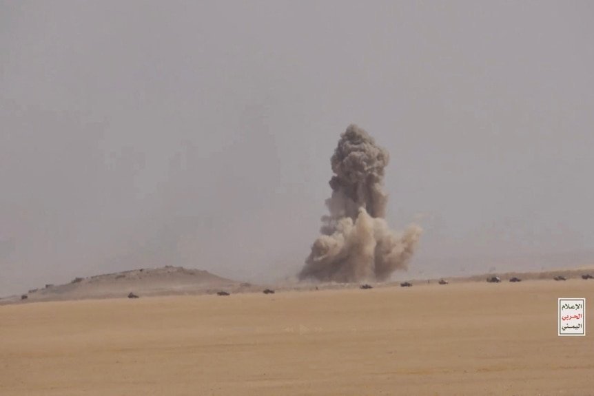 A large air strike on a far away location in a sandy desert.